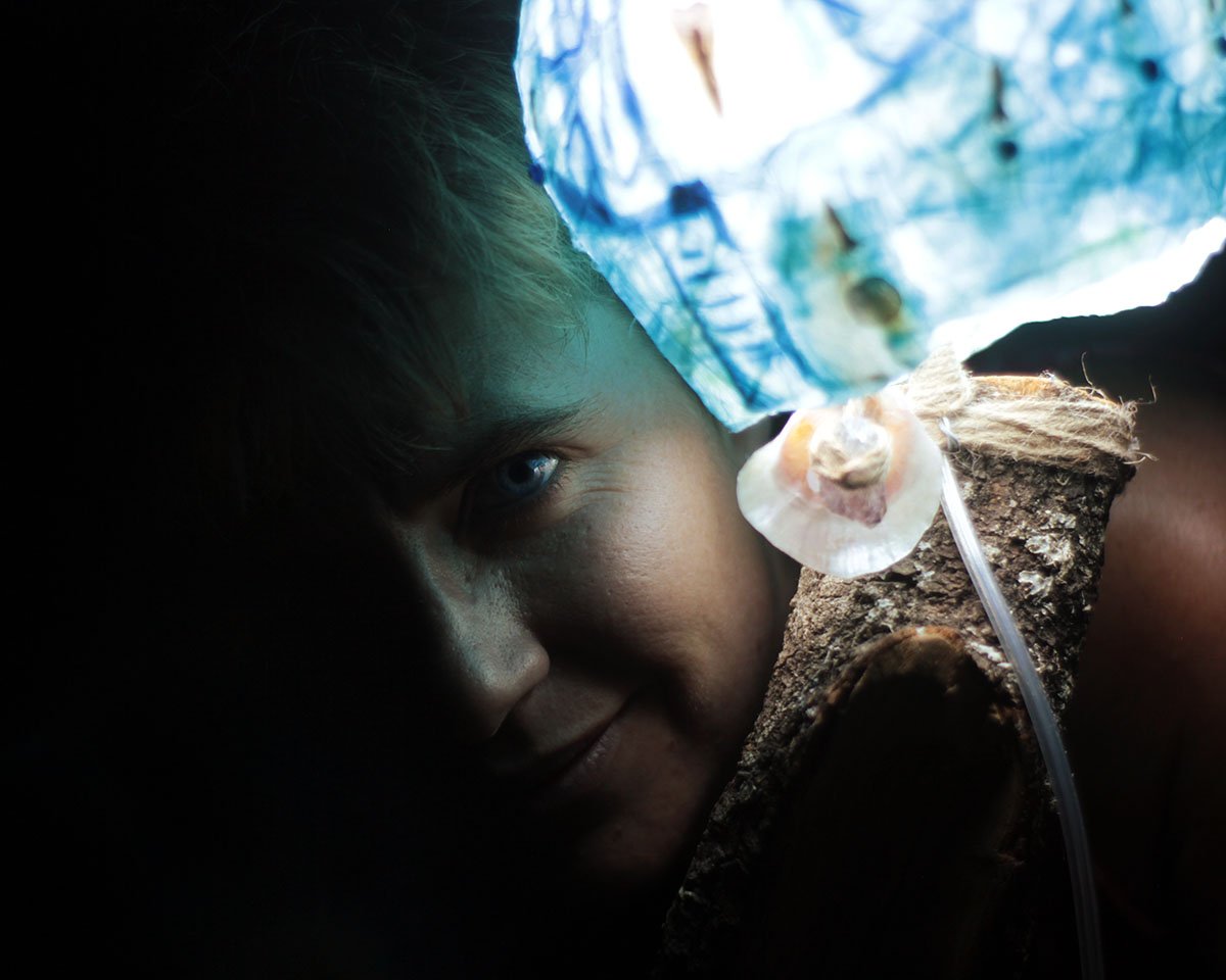 Artesano trabajando en una lámpara ONIVITA, incrustando flores secas en la pantalla.